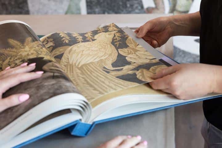 Geöffnetes Tapetenbuch mit grossem echten Tapetenmuster im Showroom