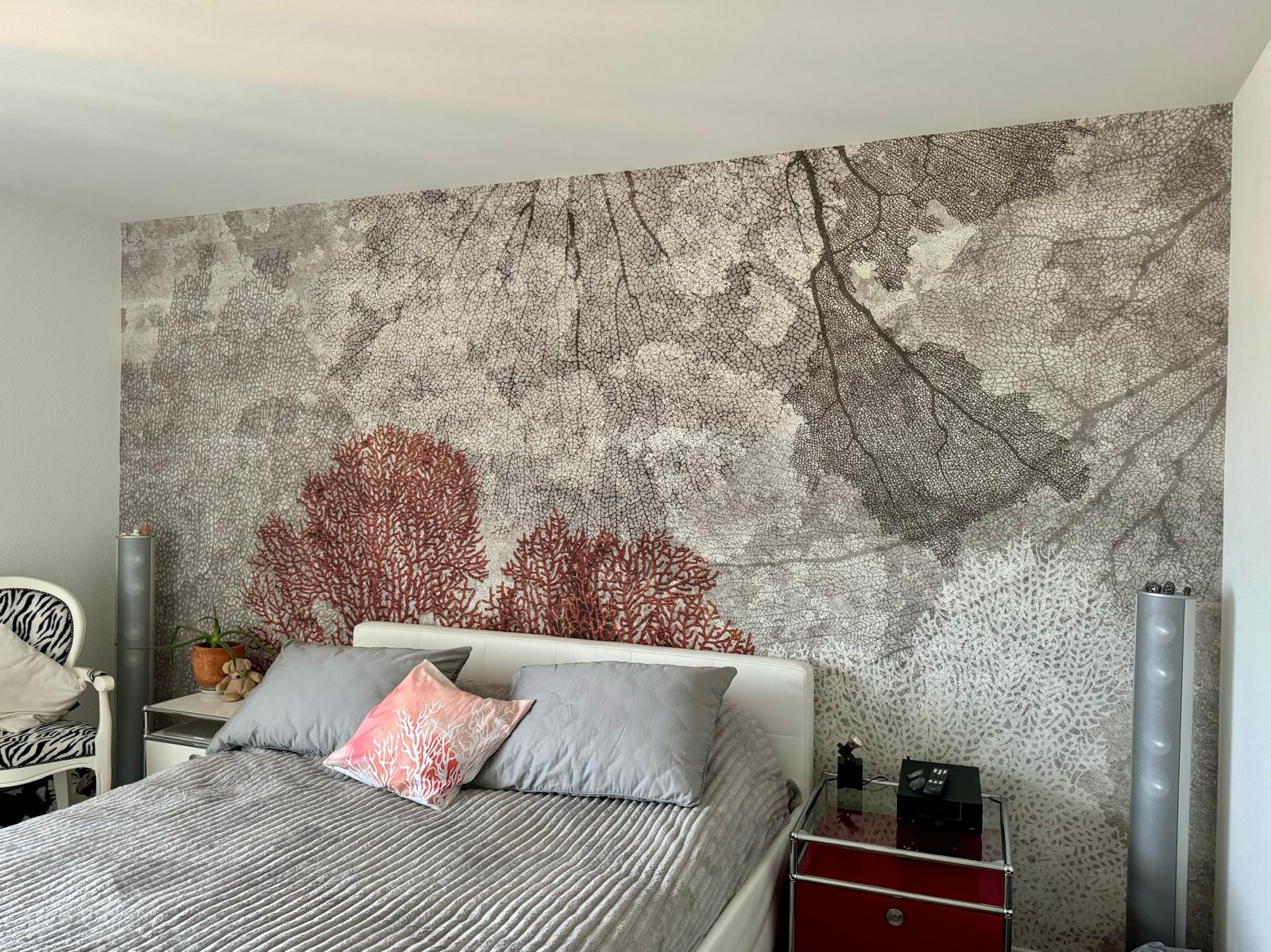 Grossformatiges Tapetenmotiv mit Korallen hinter einem Bett in einem ausgeführten Schlafzimmerprojekt