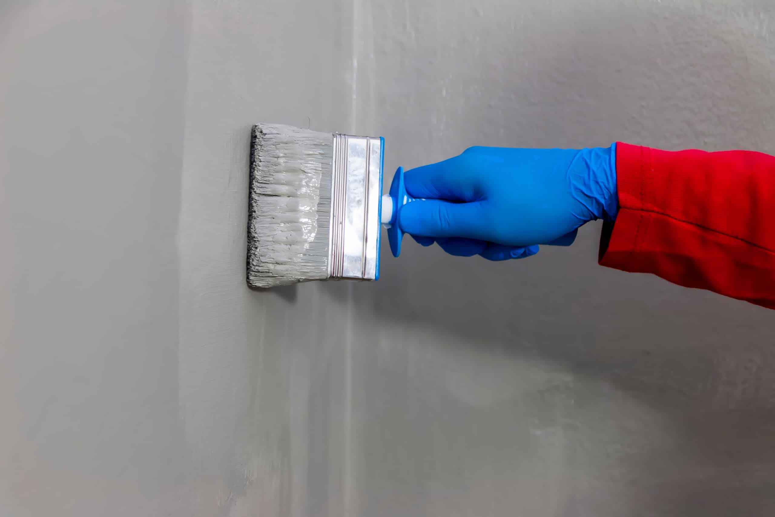 Symbolbild: graue Abdichtung wird im Badezimmer aufgetragen