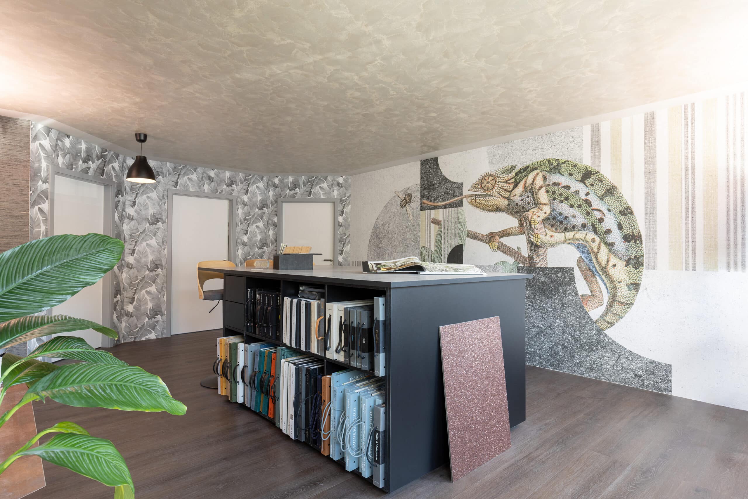 Tapeten-Showroom von Tapetenmeister mit grossformatiger Chamäleon-Wandgestaltung und Tapetenbüchern
